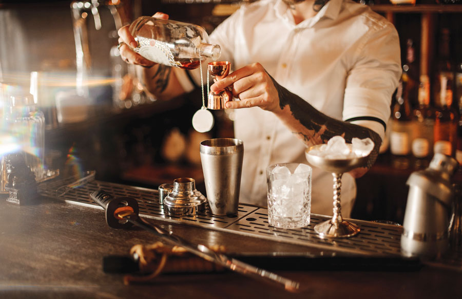 A bartender mixing drinks on a bar