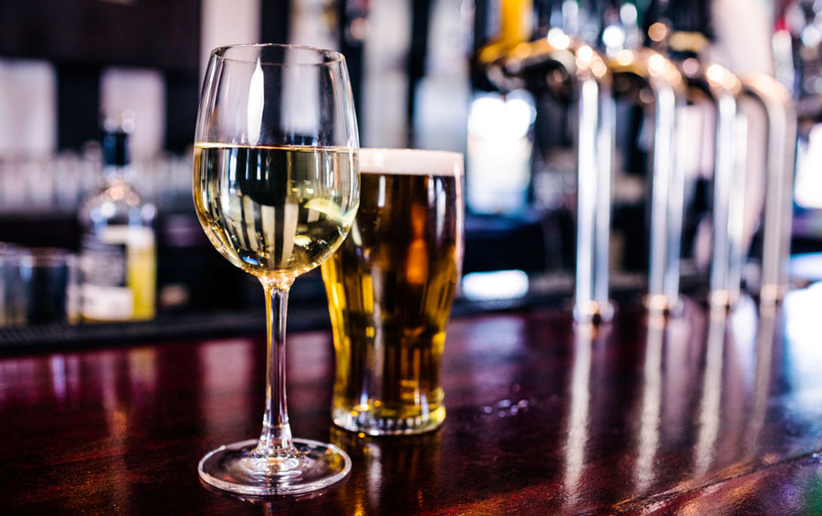 View of a glass of wine and a glass of beer on a bar