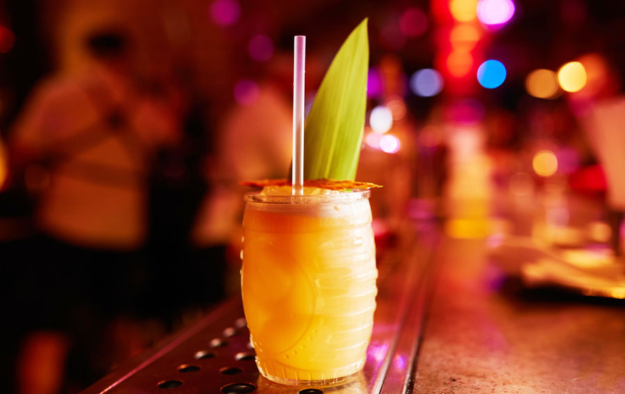 View of a cocktail with straw on a bar