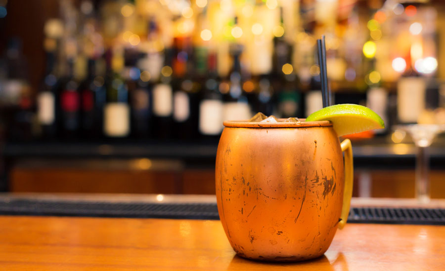 View of a alcoholic drink on a copper mug on a bar