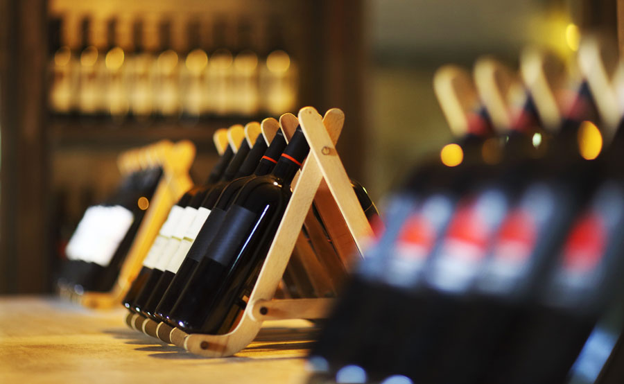 View of wine bottles on a wooden shelf in a bar