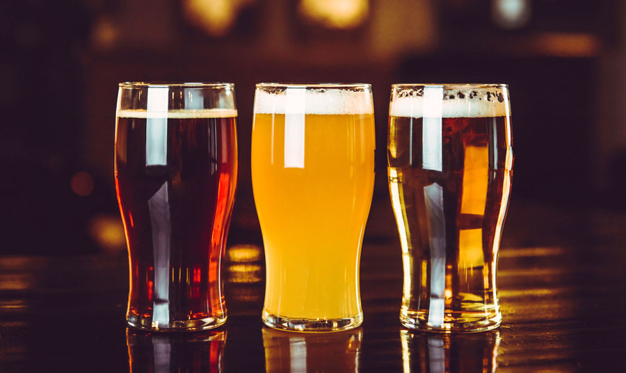 View of three glasses of beers in different color on a table
