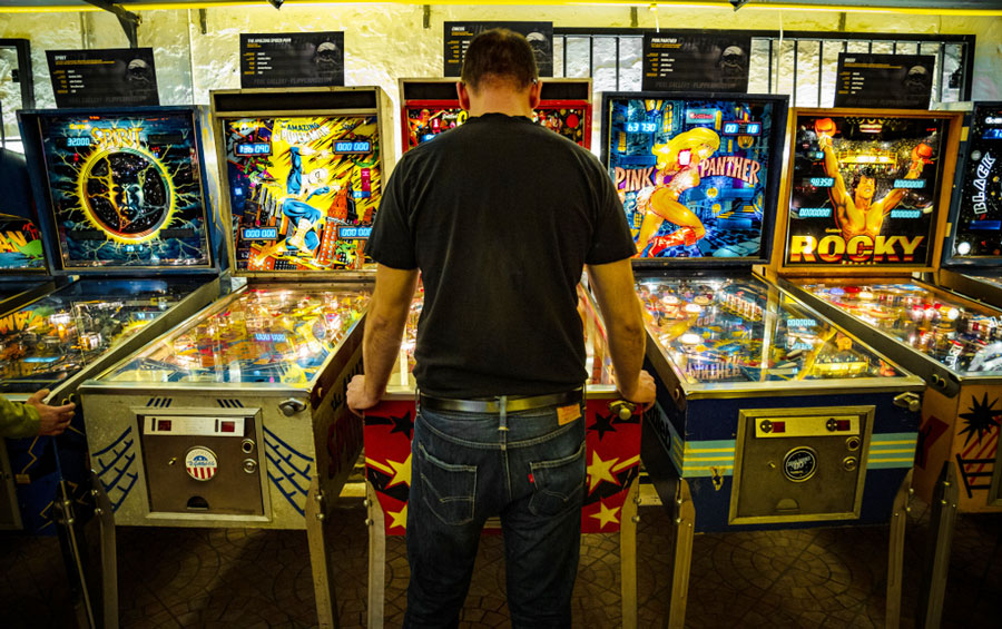 View of a man playing the pinball arcade game