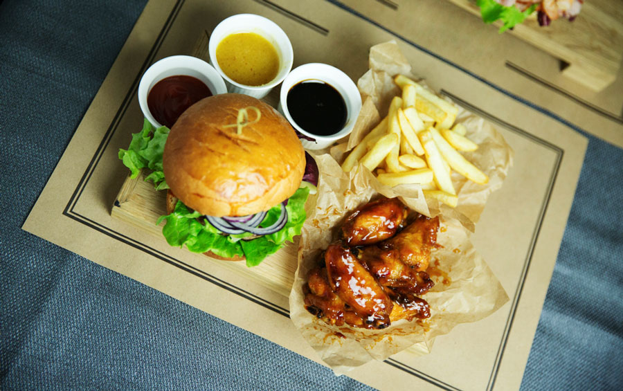 Burgers, wings, and fries on a wooden board