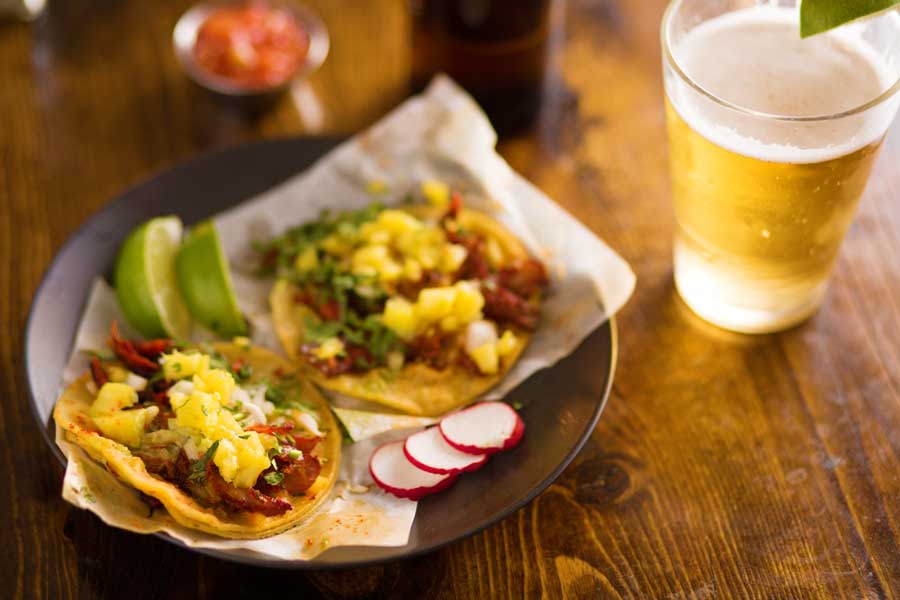 Tacos on a plate and a glass of beer