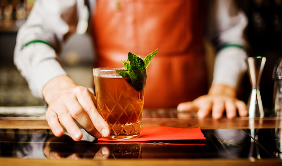 View of a bartender serving an alcoholic drink in a bar