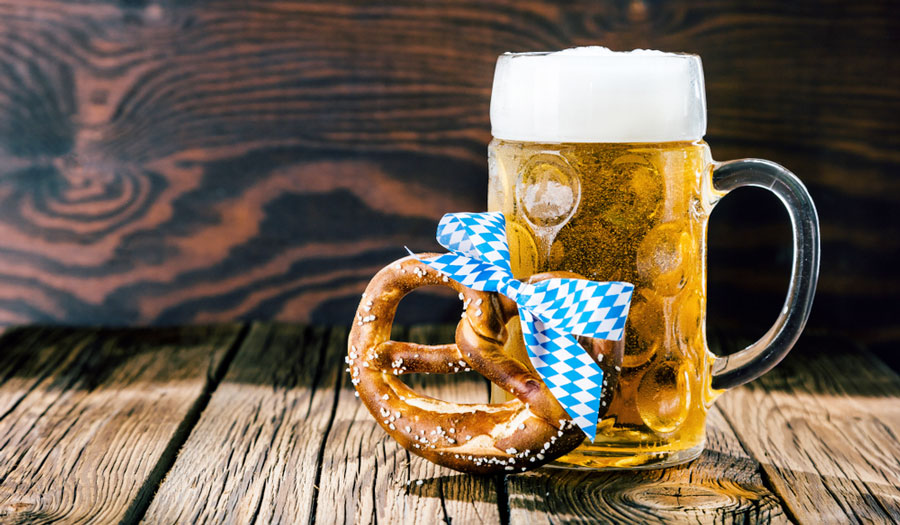 View of a glass of beer and a pretzel with ribbon