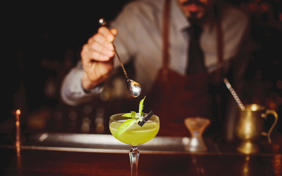 View of a bartender mixing a drink on a bar