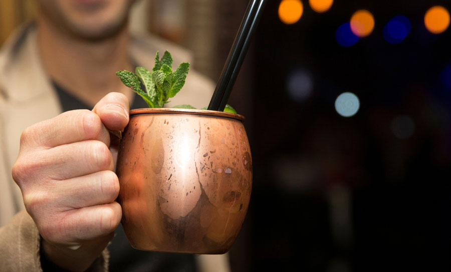 View of a man holding a moscow mule cocktail