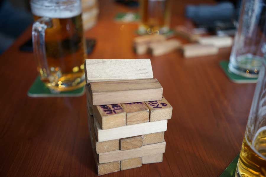 View of a tower of jenga and glasses of beer on a table