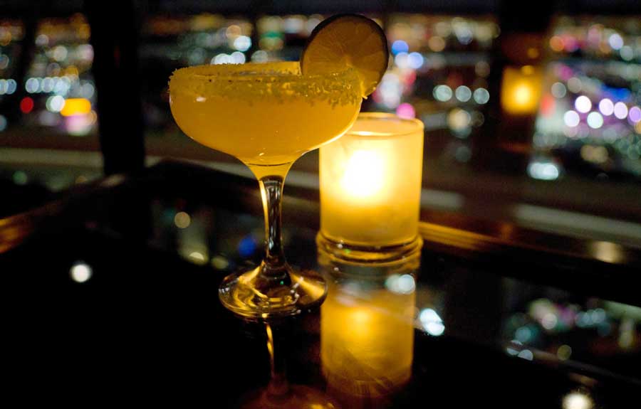 View of a cocktail and candle on a dim light
