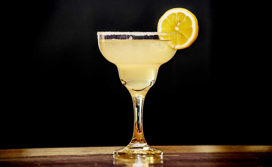 View of a cocktail with sugar on the glass of the rim and a lemon
