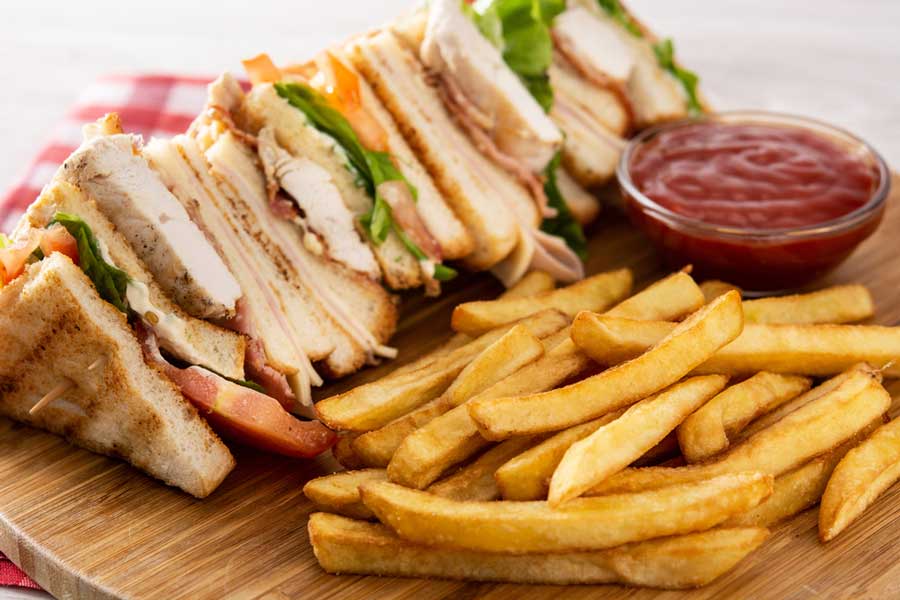 View of sandwiches and fries on a wooden board