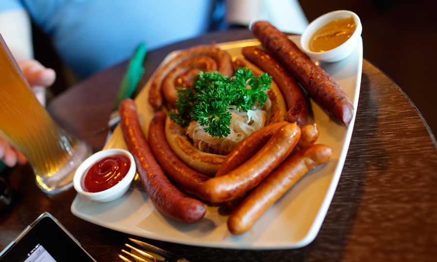 Sausages with dip on a plate and a glass of beer