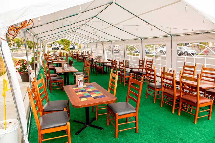 View of an outdoor tent dining with chairs and tables